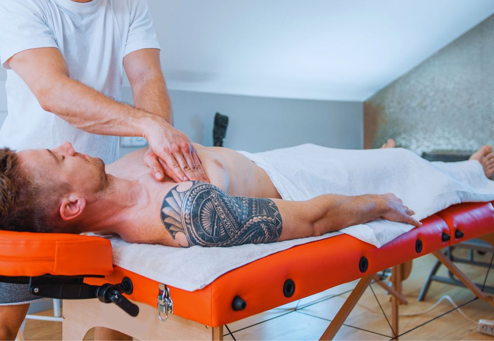 Therapist giving a chest and shoulder massage to a client on a portable massage table